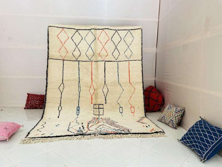 Lifestyle shot of a multicolor Moroccan rug featuring an abstract design in cream, blue, and red.