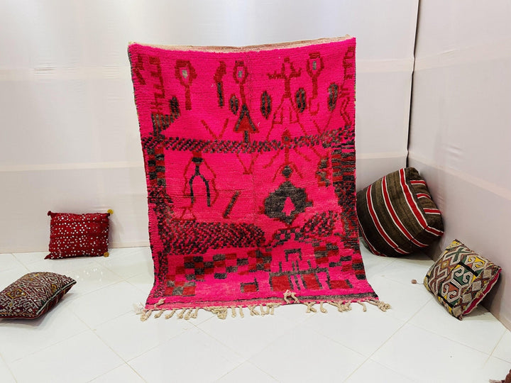 Lifestyle shot of a red vintage Boujaad Moroccan rug with tribal patterns in a studio setting.