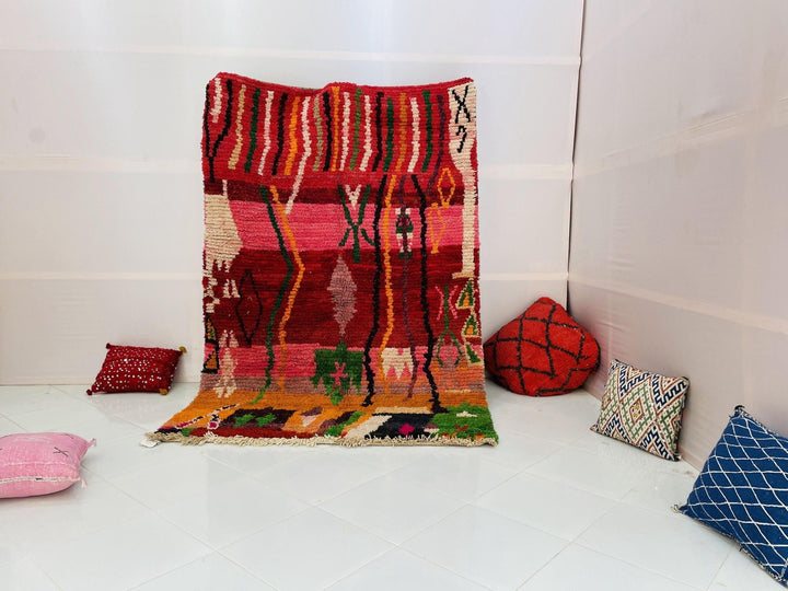 Lifestyle shot of the purple and pink vintage Boujaad Moroccan rug on a white background.