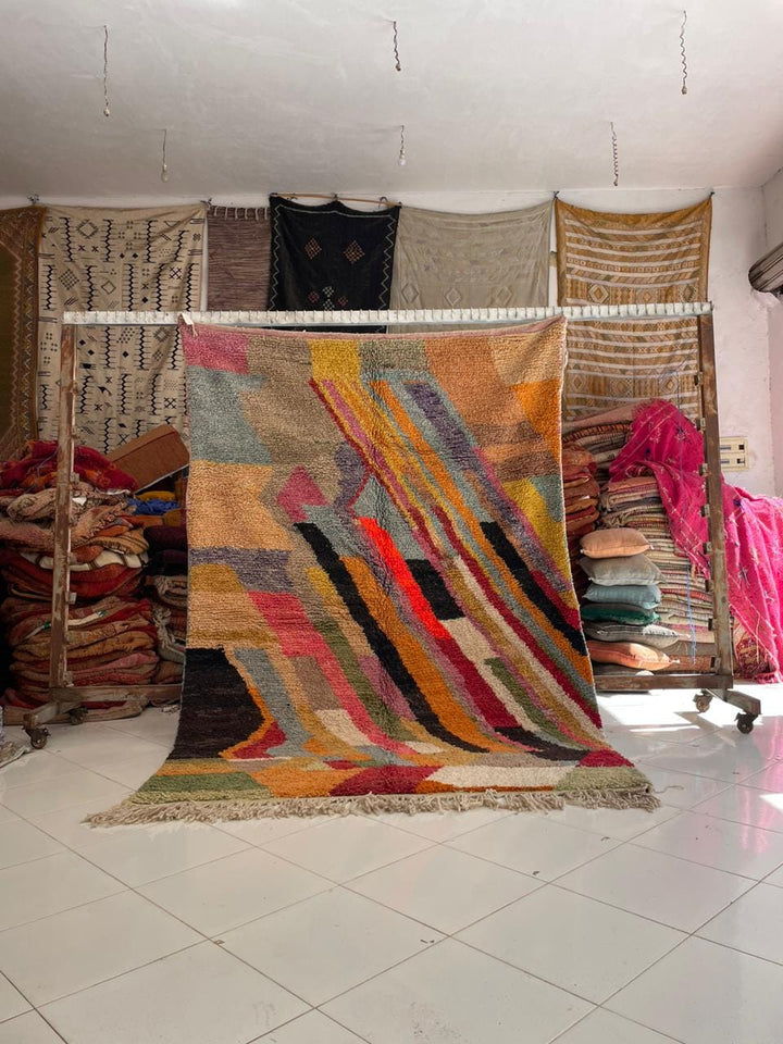 Lifestyle shot of a colorful vintage Moroccan rug with tribal patterns in red, yellow, and blue.