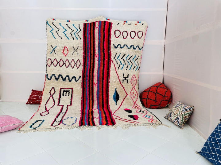 Lifestyle shot of a multicolor Moroccan Boujaad rug featuring tribal patterns on a white background.