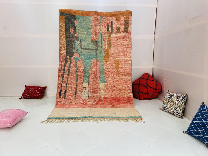 Lifestyle shot of the Abstract Tribal Boujaad Moroccan Rug featuring orange, blue, and pink tribal patterns.