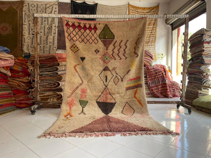 Lifestyle shot of the Moroccan Boujaad rug featuring geometric patterns in beige, brown, and green.