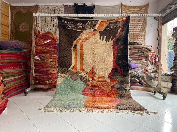 Lifestyle shot of a vintage Boujaad Moroccan rug featuring brown, orange, and green colors.