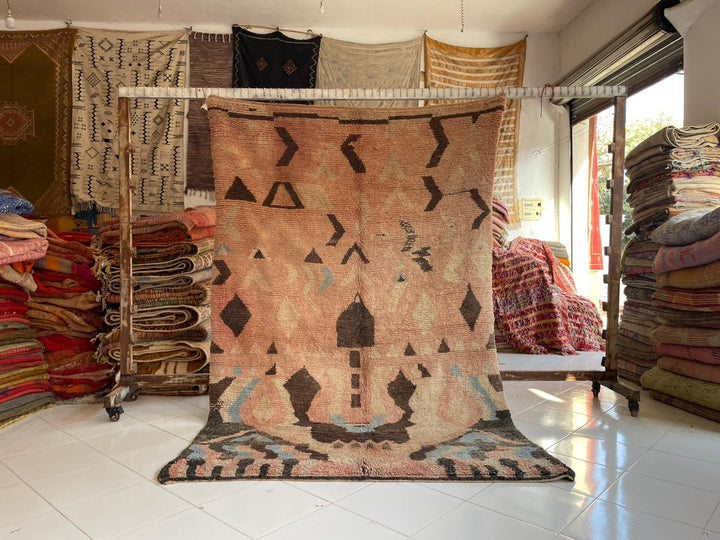 Lifestyle shot of a colorful Boujaad rug with geometric patterns in brown, black, and blue.