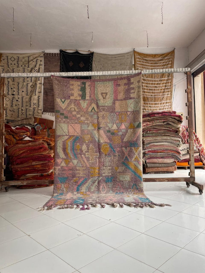 Lifestyle shot of a colorful vintage Moroccan rug with geometric patterns in a natural setting.