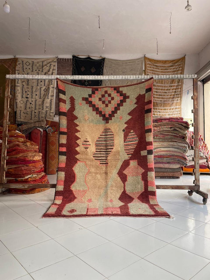 Lifestyle shot of a colorful Moroccan rug featuring geometric patterns in red and beige.