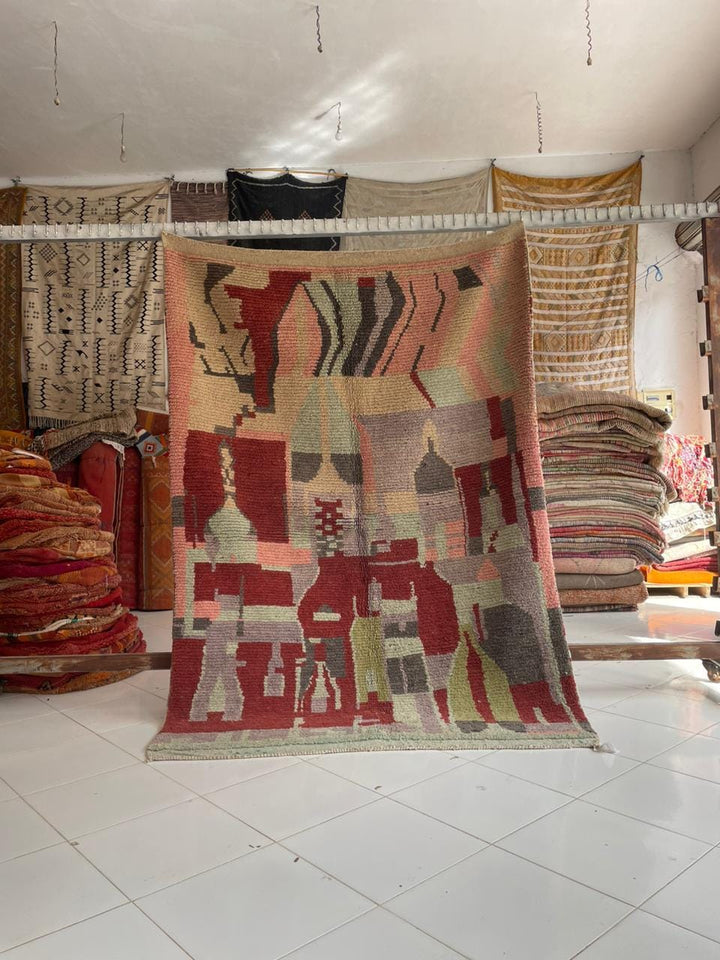 Detail view of a colorful Moroccan rug featuring geometric patterns in red, green, and pink.