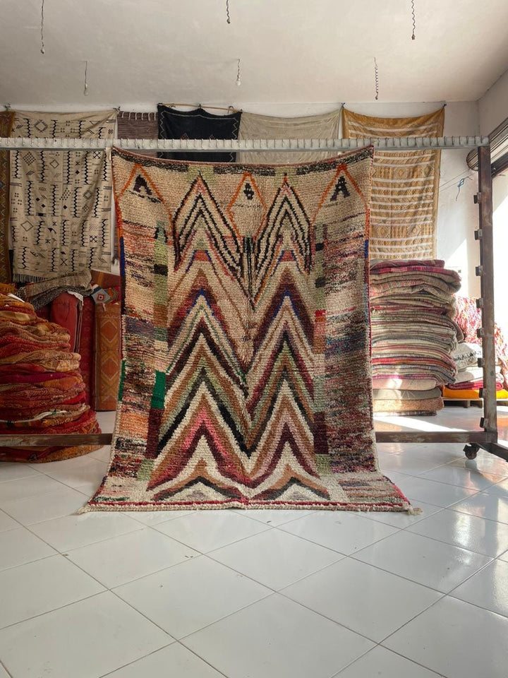 Lifestyle shot of a colorful Moroccan rug with zigzag pattern in a natural setting.