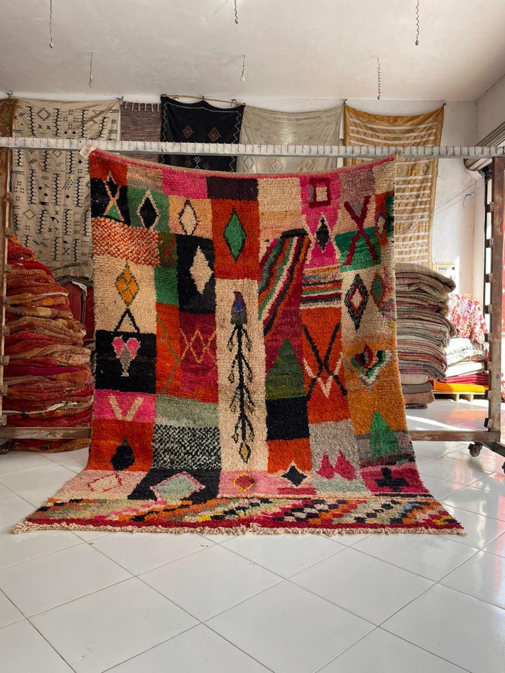 Lifestyle shot of a colorful Moroccan rug featuring geometric patterns on a natural background.