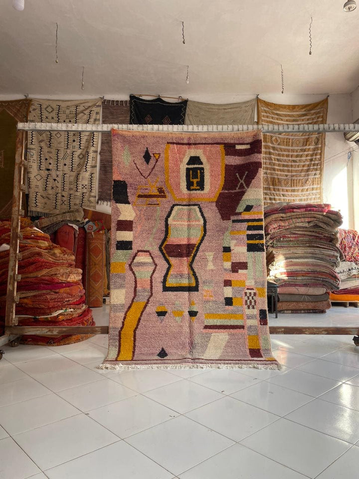 Lifestyle shot of the red and pink Moroccan rug featuring geometric patterns and fringe edges.