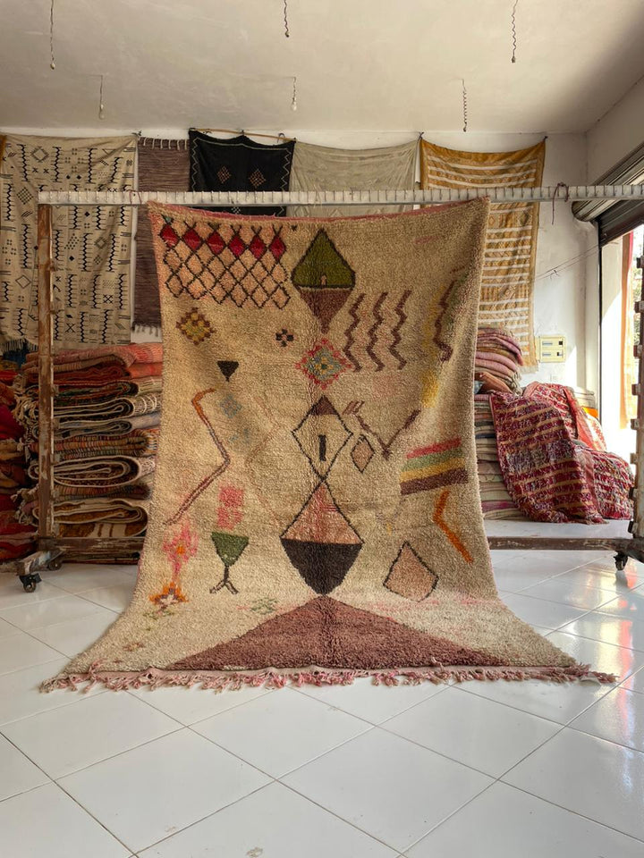 Detail view of a colorful vintage Moroccan rug featuring fringe edges and geometric patterns.