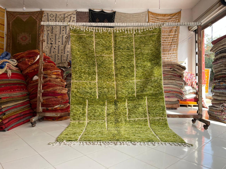 Lifestyle shot of a green Berber rug in a studio setting, showcasing its vintage design.