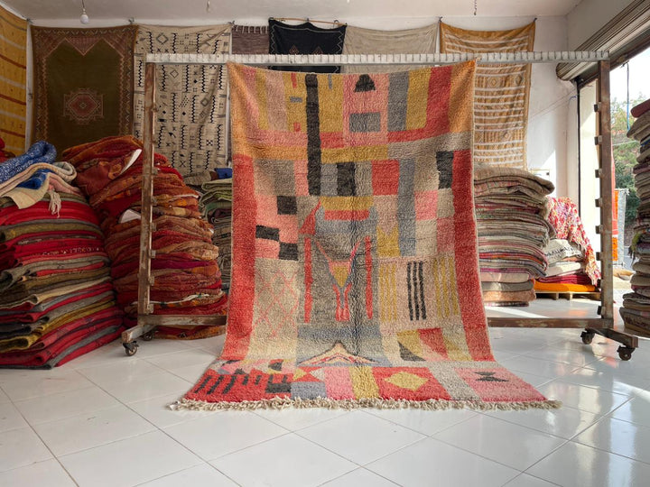 Lifestyle shot of a pink vintage Boujaad Moroccan rug with geometric patterns and fringe edges.