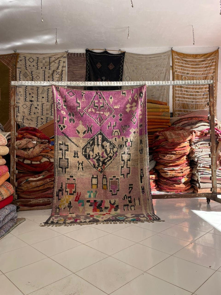 Lifestyle shot of a vintage Moroccan rug featuring intricate patterns in purple and beige.