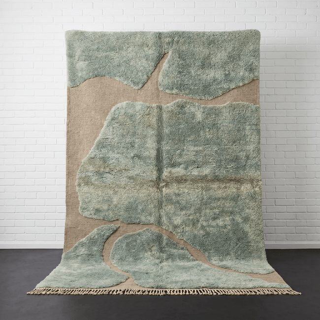 Front view of the sage green Moroccan rug featuring an abstract pattern on a studio background.