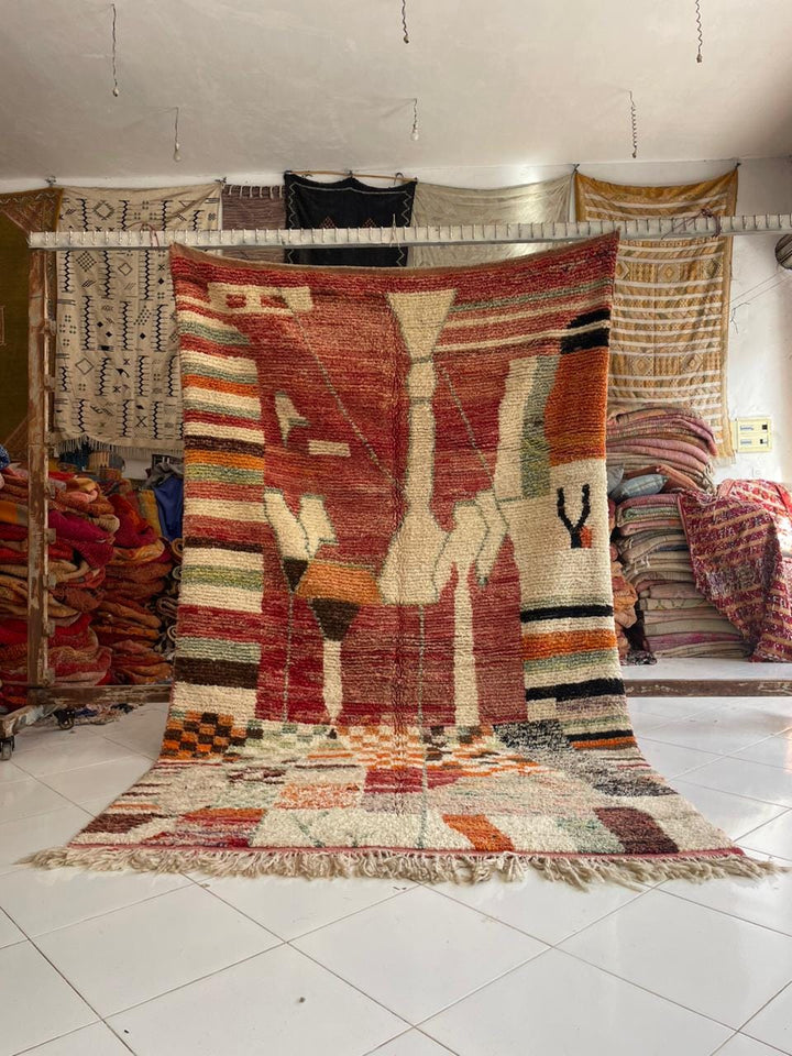 Lifestyle shot of a vintage Moroccan rug featuring geometric patterns in red and cream.