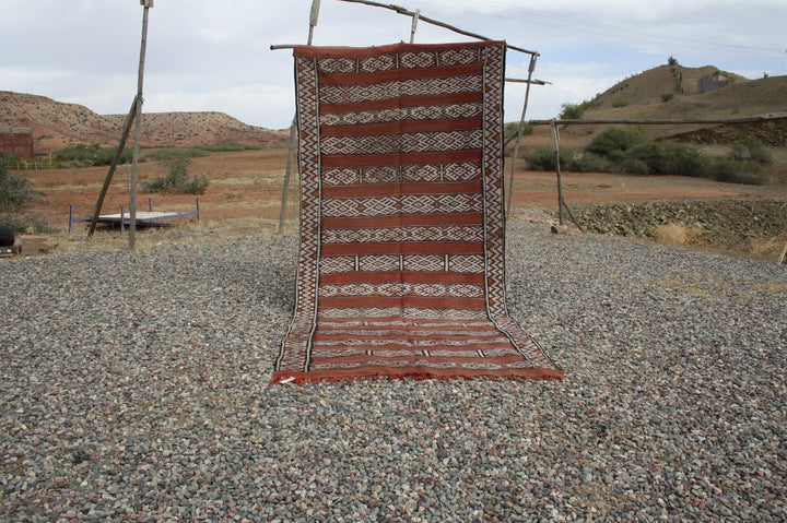 Front view of the vintage kilim rug featuring a striped pattern in red and brown.