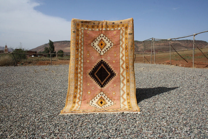 Lifestyle shot of the vintage kilim rug featuring geometric patterns in orange and black.