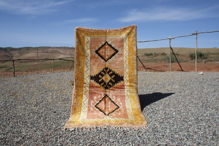 Lifestyle shot of a vintage kilim runner featuring geometric patterns in orange, black, and cream.