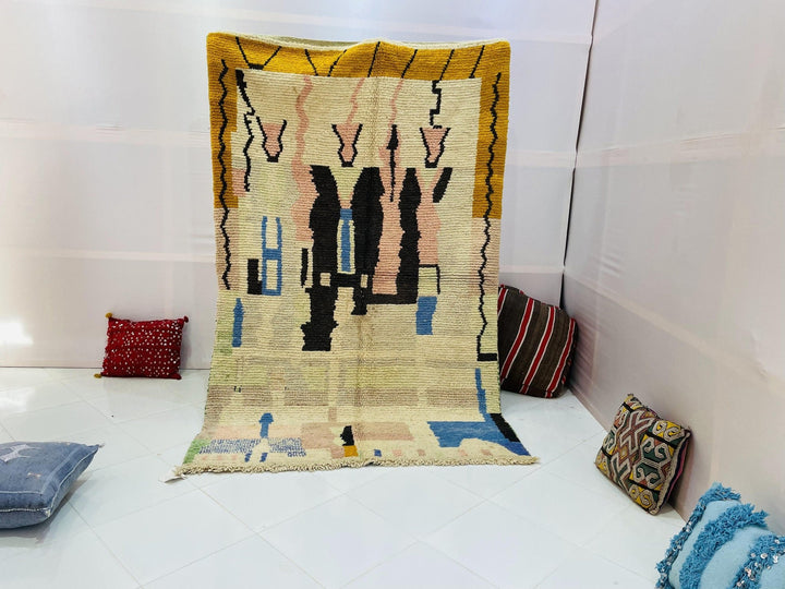 Lifestyle shot of a vintage Moroccan rug with abstract design in beige, blue, and black.