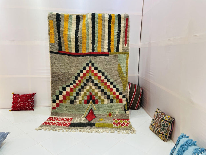 Lifestyle shot of a beige and red geometric Moroccan rug with fringe edges.