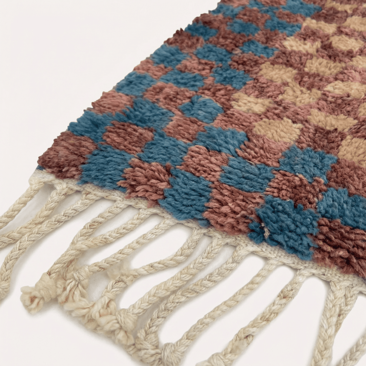 Front view of the burgundy checkered rug featuring a checkered pattern in a studio setting.
