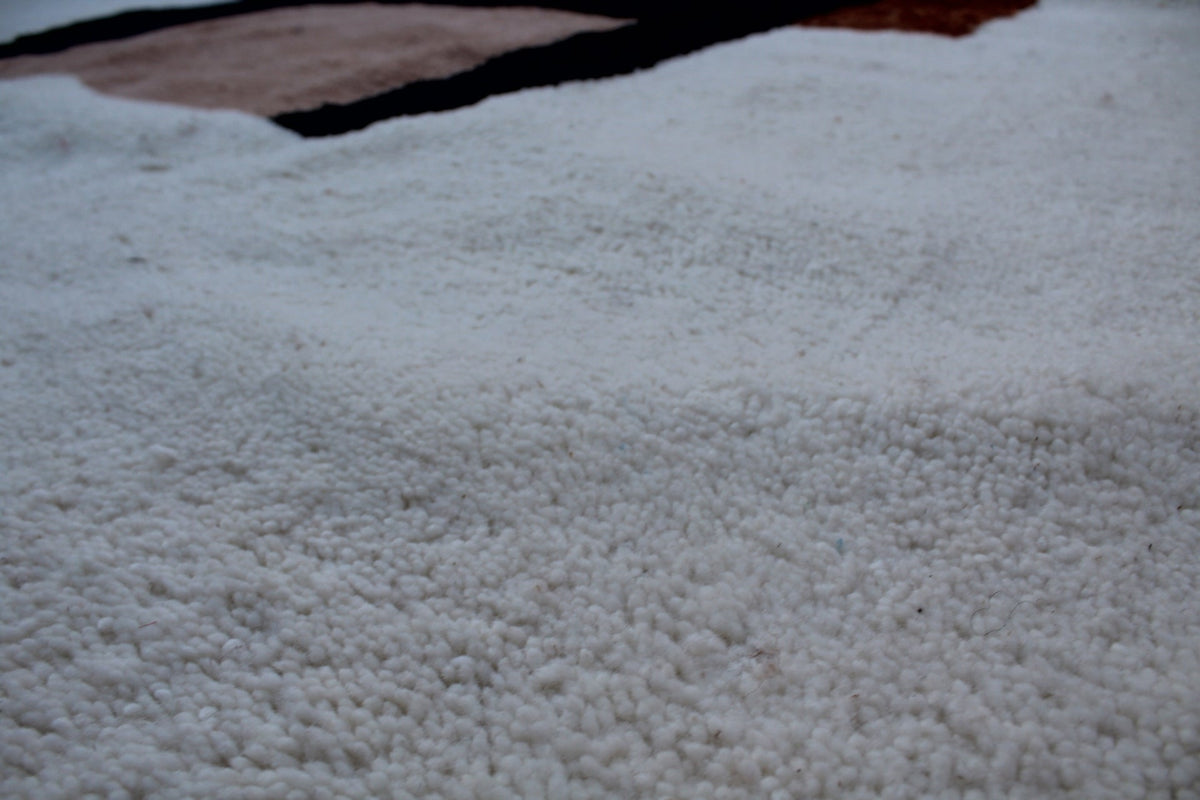 Close-up detail of a Moroccan Beni Ourain rug with a textured surface in white.