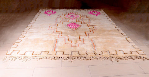 Front view of a beige, pink, and brown Berber rug with geometric patterns and fringe edges.