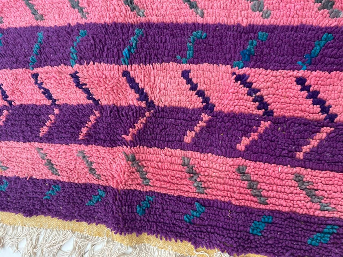 Detail shot of a pink Moroccan rug with bold colors and a unique design.