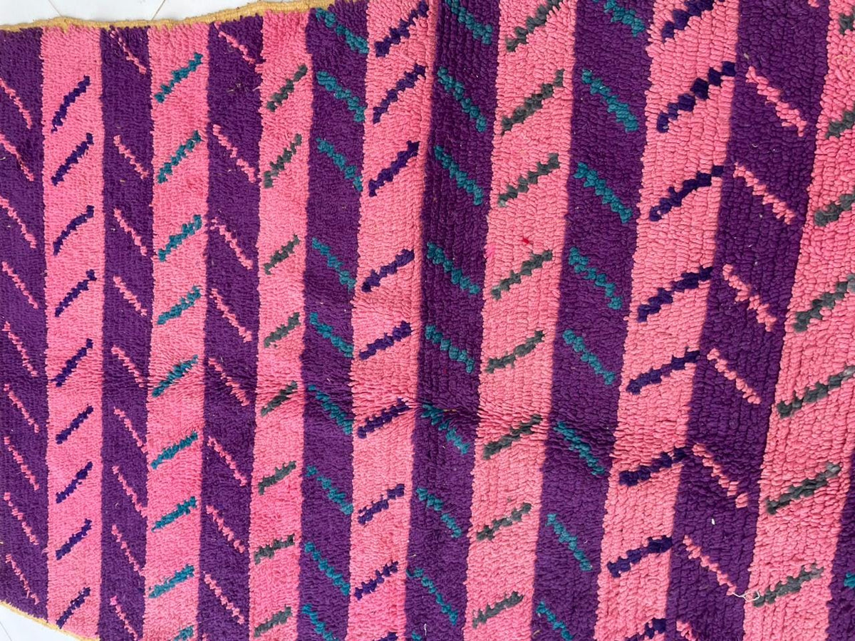 Close-up of a pink Moroccan rug displaying vibrant hues and a textured weave.