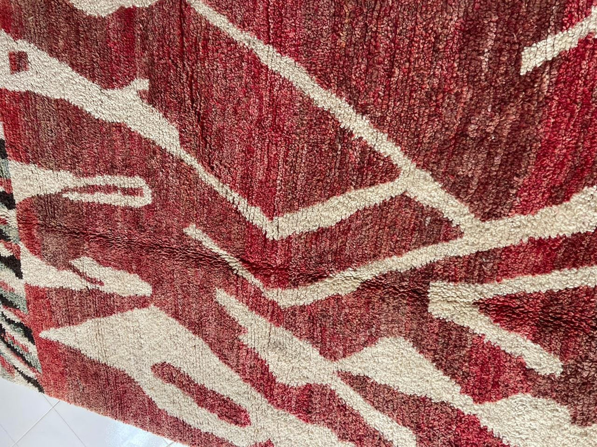 Close-up of a red Moroccan rug with a geometric pattern and textured surface.