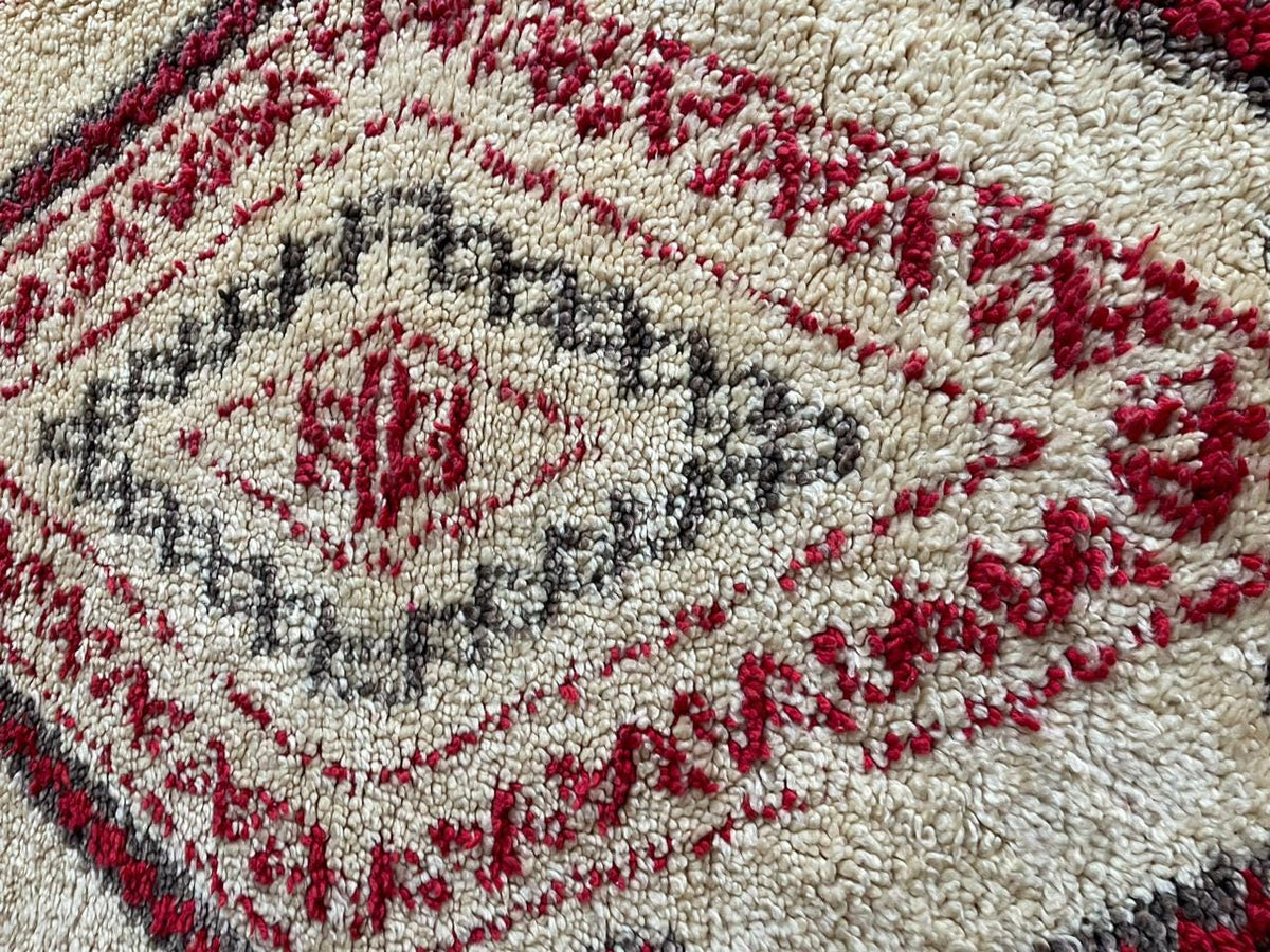Close-up detail of the intricate texture of a red Moroccan rug.