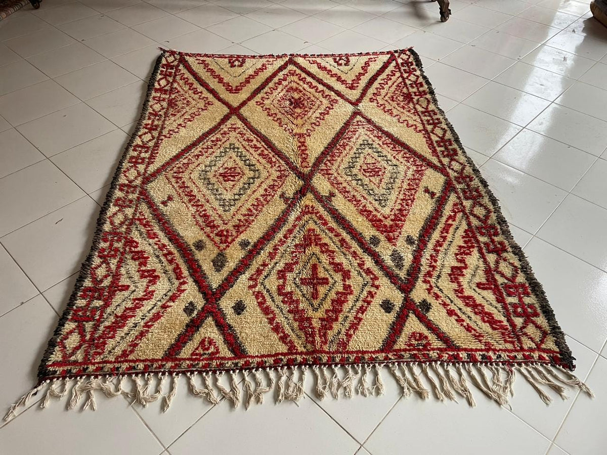 Front view of a red Moroccan rug featuring diamond patterns against a solid background.