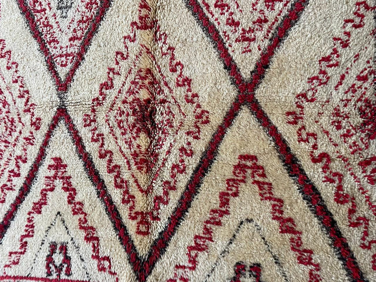 Detail view showcasing the geometric designs on a red Moroccan rug.