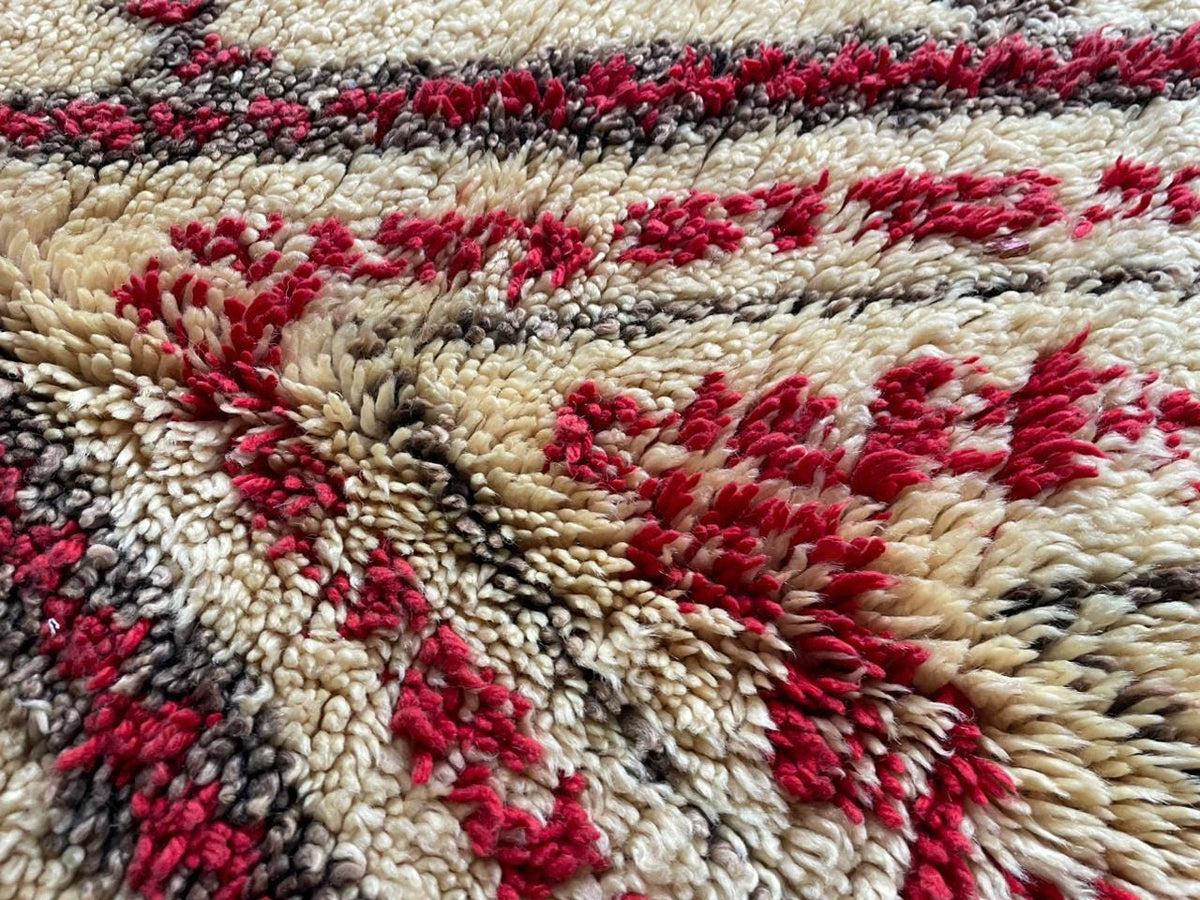 Close-up of a red Moroccan rug highlighting geometric patterns and textured wool.