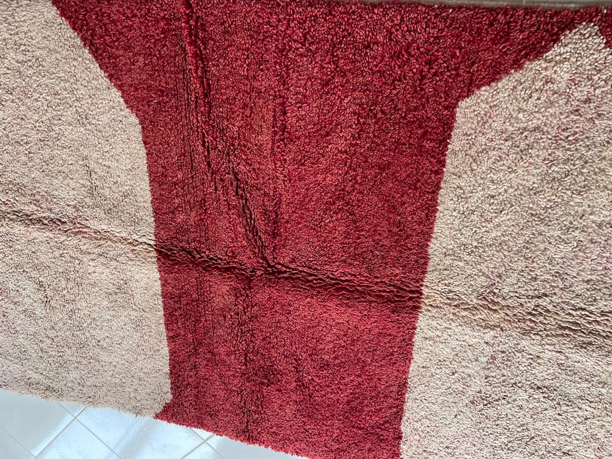 Detail close-up of a vintage Moroccan rug with a geometric pattern and textured surface.