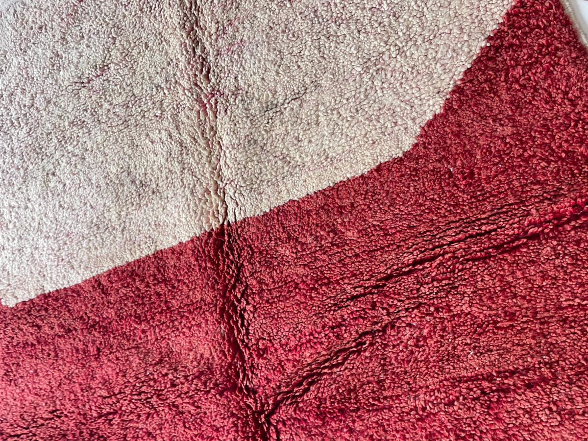 Detail close-up of a vintage Moroccan rug featuring a geometric pattern and textured surface.