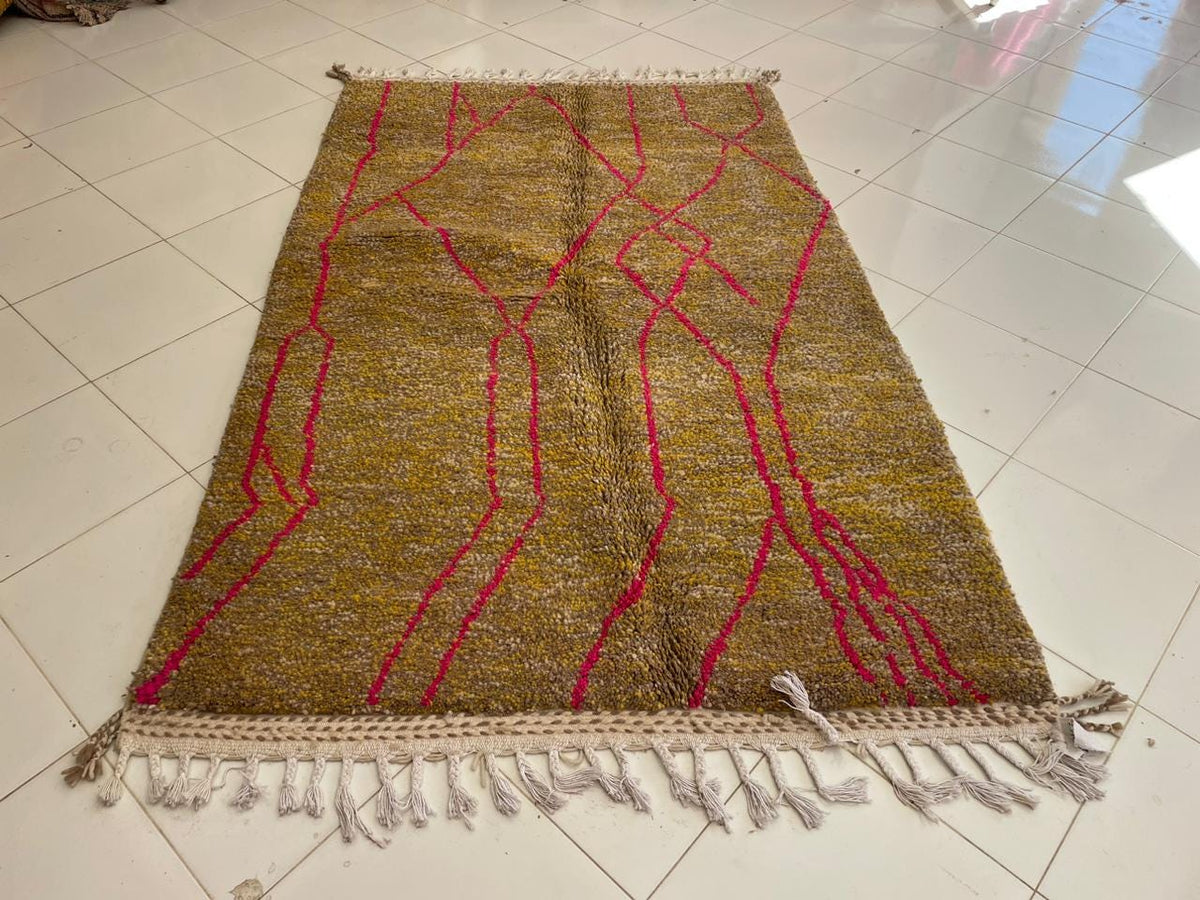 Front view of a vintage Moroccan rug showcasing fringe edges and geometric patterns in gold and red.