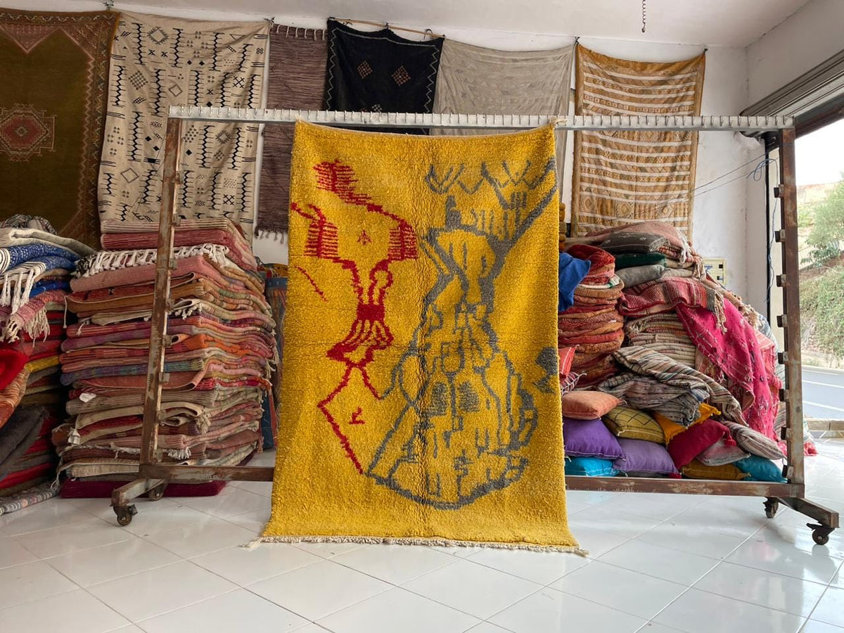 Lifestyle shot of a hanging yellow Moroccan rug with decorative designs.