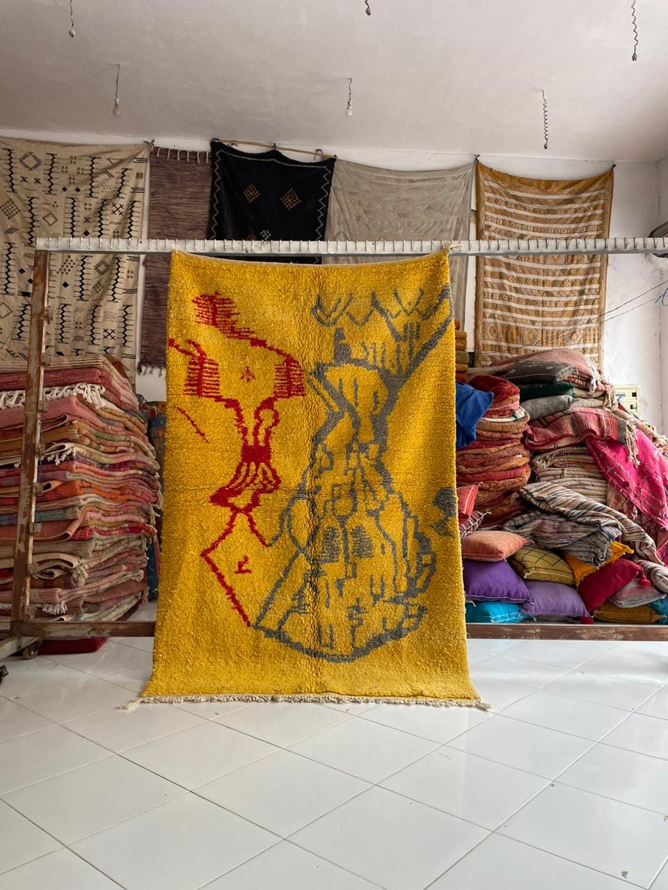Lifestyle shot of a yellow Moroccan rug with geometric patterns and fringe edges.