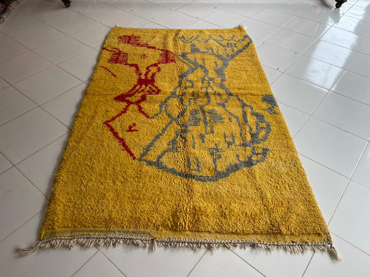 Top view of a yellow Moroccan rug featuring geometric patterns on a solid background.