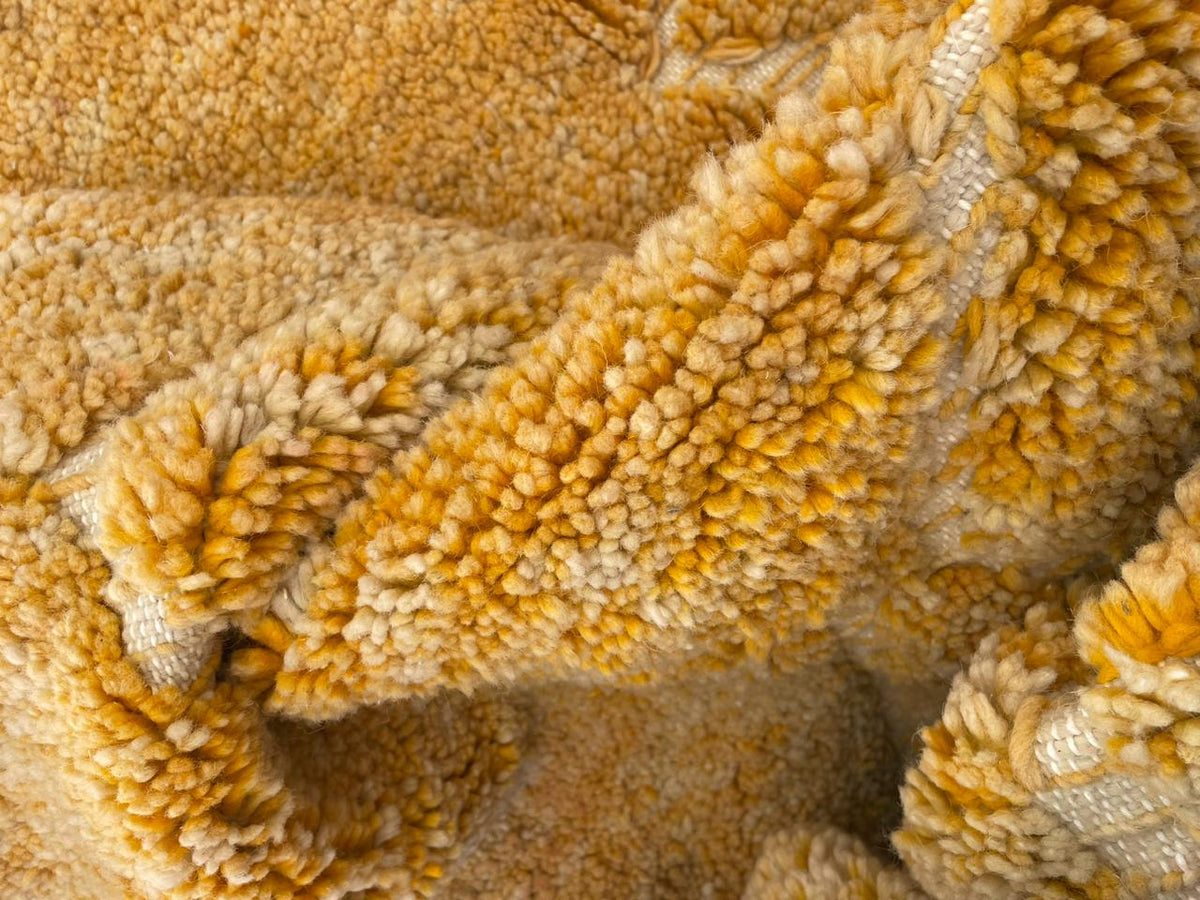 Detail shot of a yellow rug emphasizing its textured surface and soft fibers.