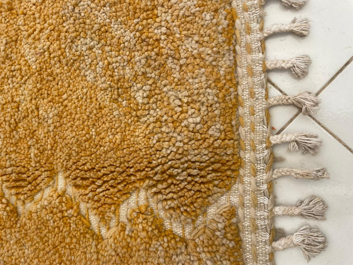 Detail shot of a yellow rug showcasing its textured surface and soft fibers.