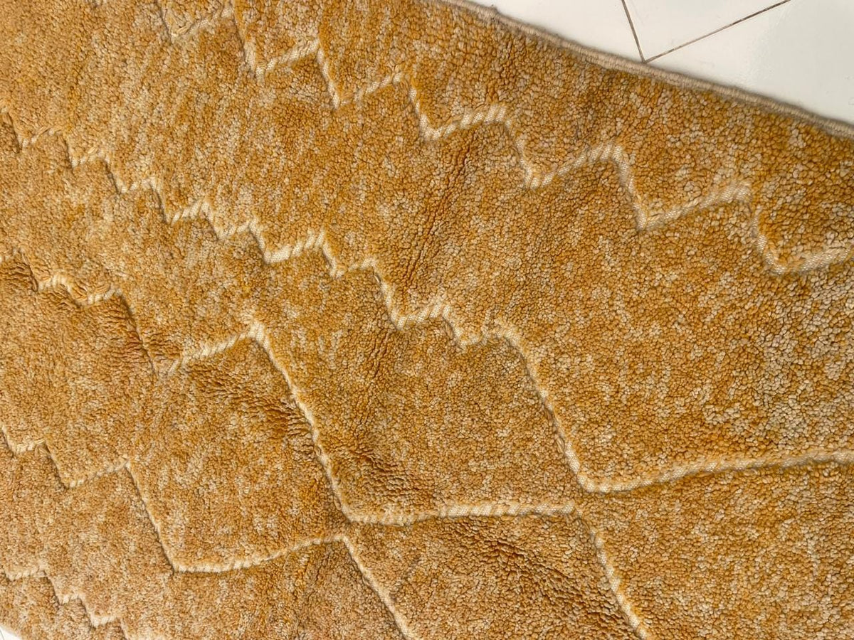 Close-up detail of a yellow rug showcasing a honeycomb pattern and textured surface.