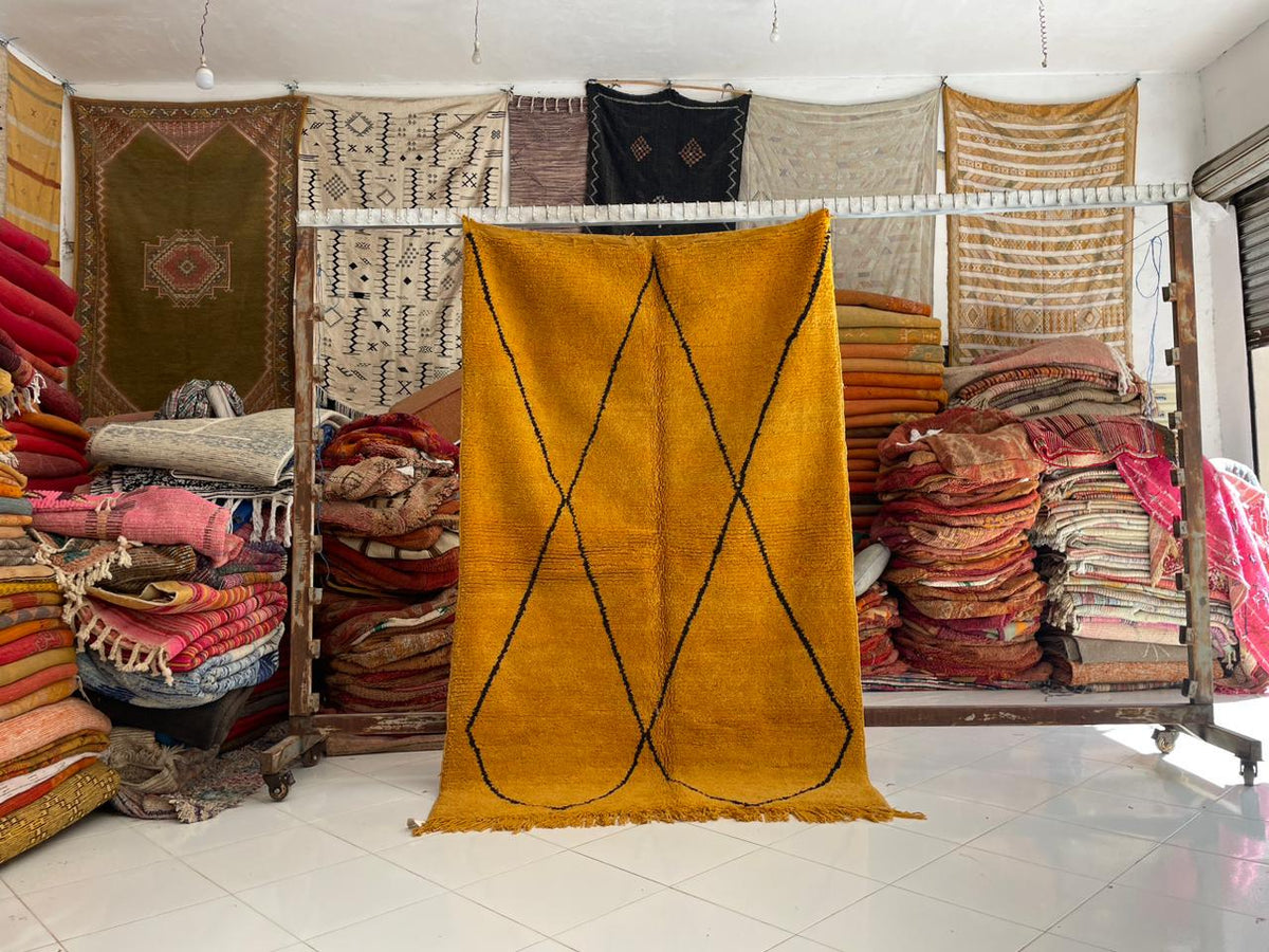 Lifestyle shot of a yellow Moroccan rug displayed decoratively in a natural setting.