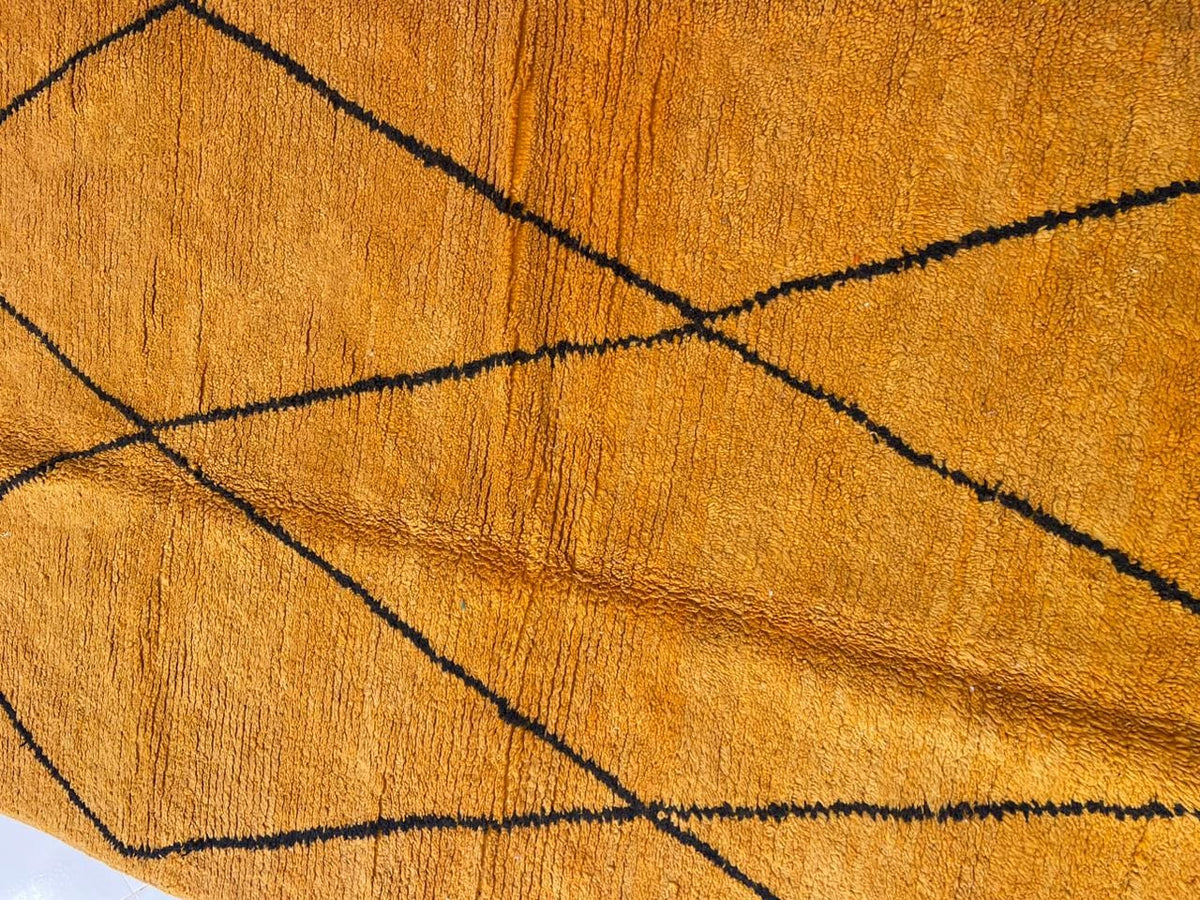 Close-up detail of a yellow Moroccan rug showcasing its geometric pattern and soft texture.