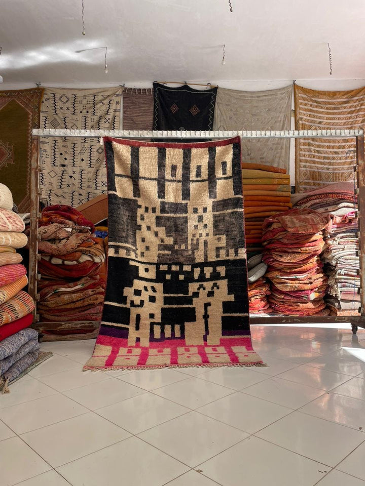 Lifestyle shot of a Moroccan tribal rug featuring black, beige, and red colors with tribal patterns.