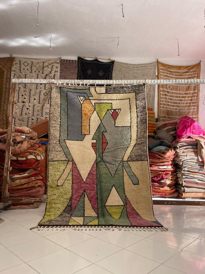 Lifestyle shot of a vintage Moroccan rug featuring tribal patterns in green, red, and yellow.