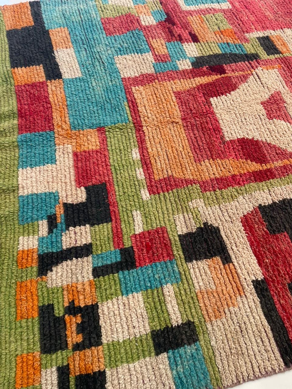 Close-up detail of a vintage Moroccan rug highlighting tribal designs in vibrant colors.